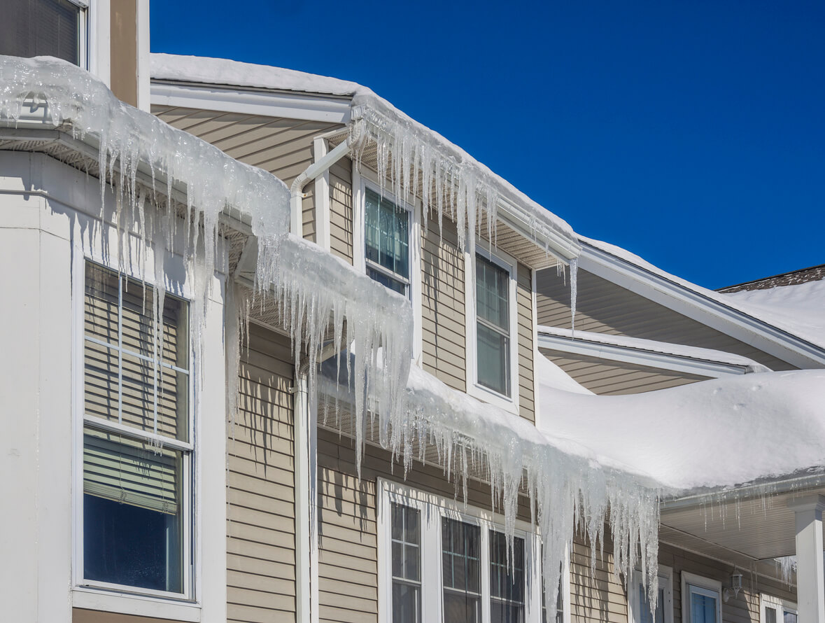 Large icicles hanging off of the eavestrough of a roof
