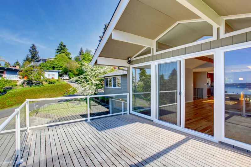 A photo of a cottage with a deck and sliding patio doors.