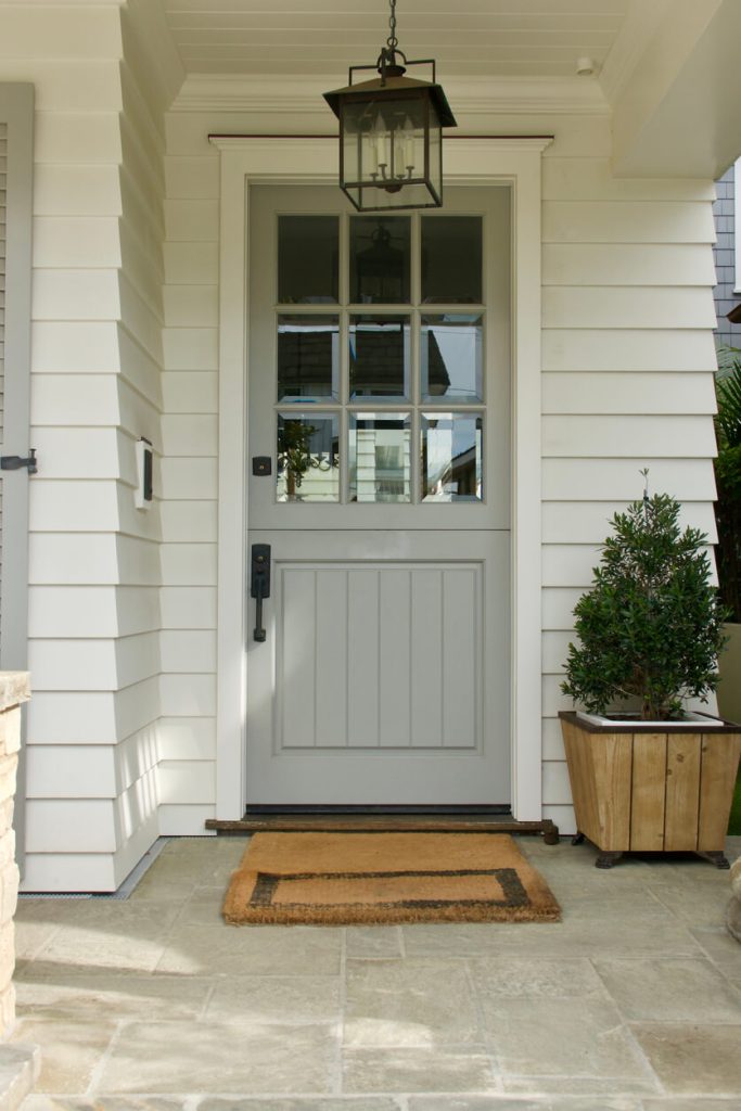 A photo of a grey door on a house with white siding.