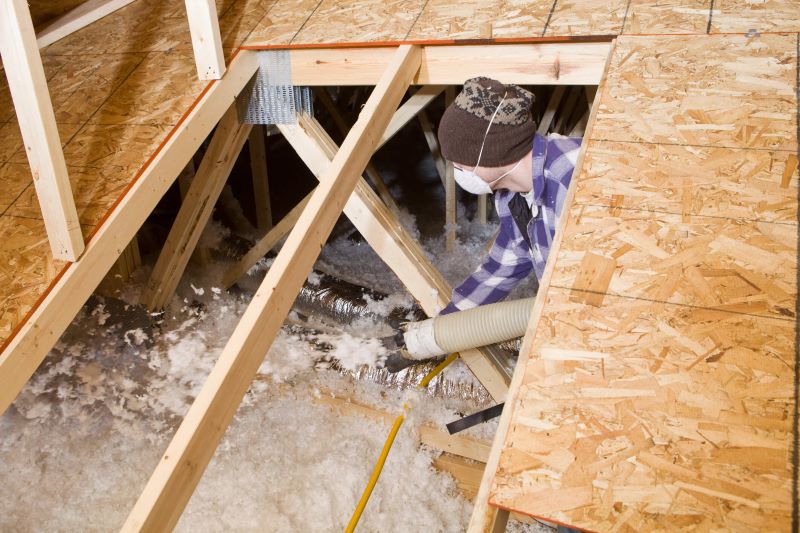A photo of a man adding insulation to an attic. 